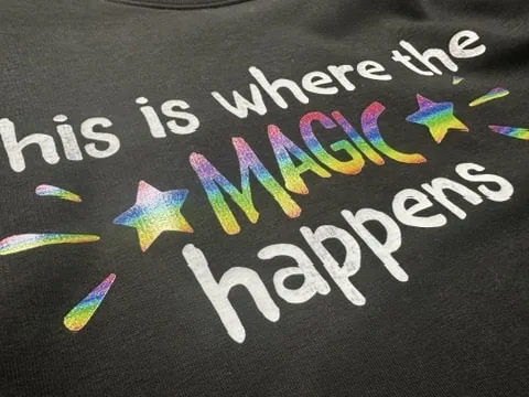 Close-up of a DTF print with rainbow lettering on a black shirt