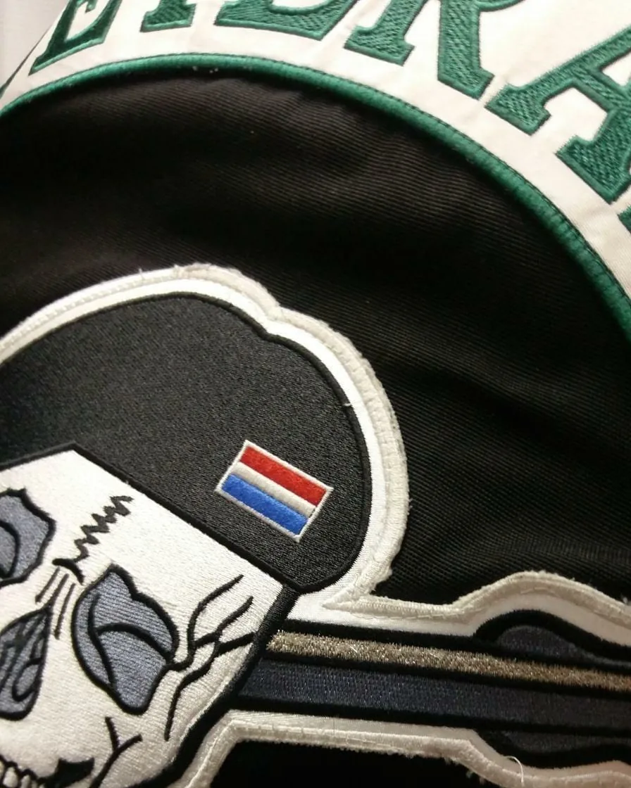 Geborduurde patch met doodshoofd en vlaggetje op een jas